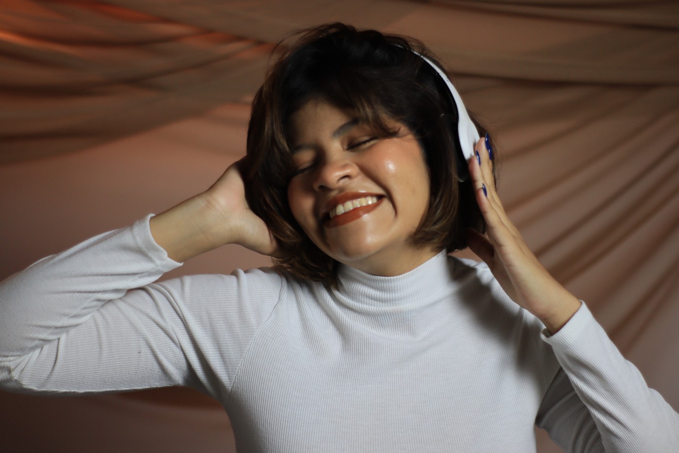 Mulher de camisa branca sorrindo durante um ensaio